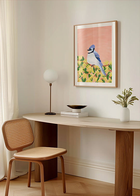 un rincón acogedor de una habitación con un escritorio de madera, una silla tejida, una lámpara y una imagen enmarcada de un pájaro azul sobre un fondo amarillo.