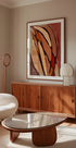 una sala de estar moderna con un gran cuadro abstracto en la pared, un mueble de madera, un sofá blanco y una mesa de centro con tapa de vidrio.