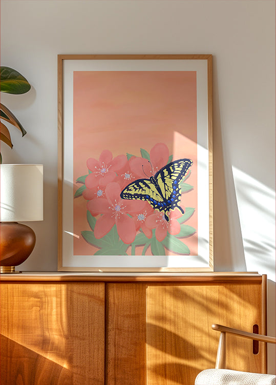 una pintura enmarcada de una mariposa sobre una flor rosa, expuesta en un gabinete o estante de madera.