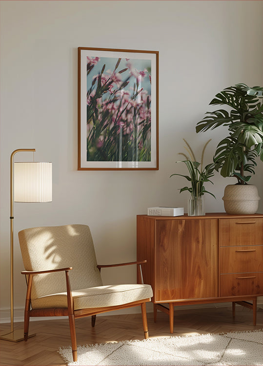 una acogedora sala de estar con un mueble de madera, un sillón beige, un cuadro enmarcado de flores rosas y una maceta.